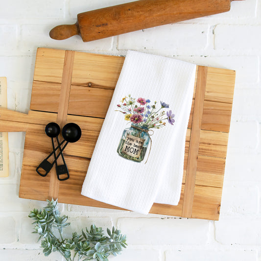 Elevate Mom's kitchen: Floral Waffle weave towel for Mother's Day joy. Flowers in a glass jar for the best mom.