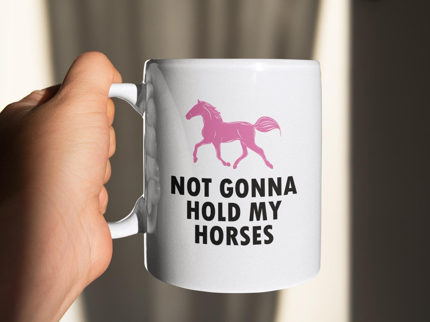 a person holding a coffee mug with a horse on it