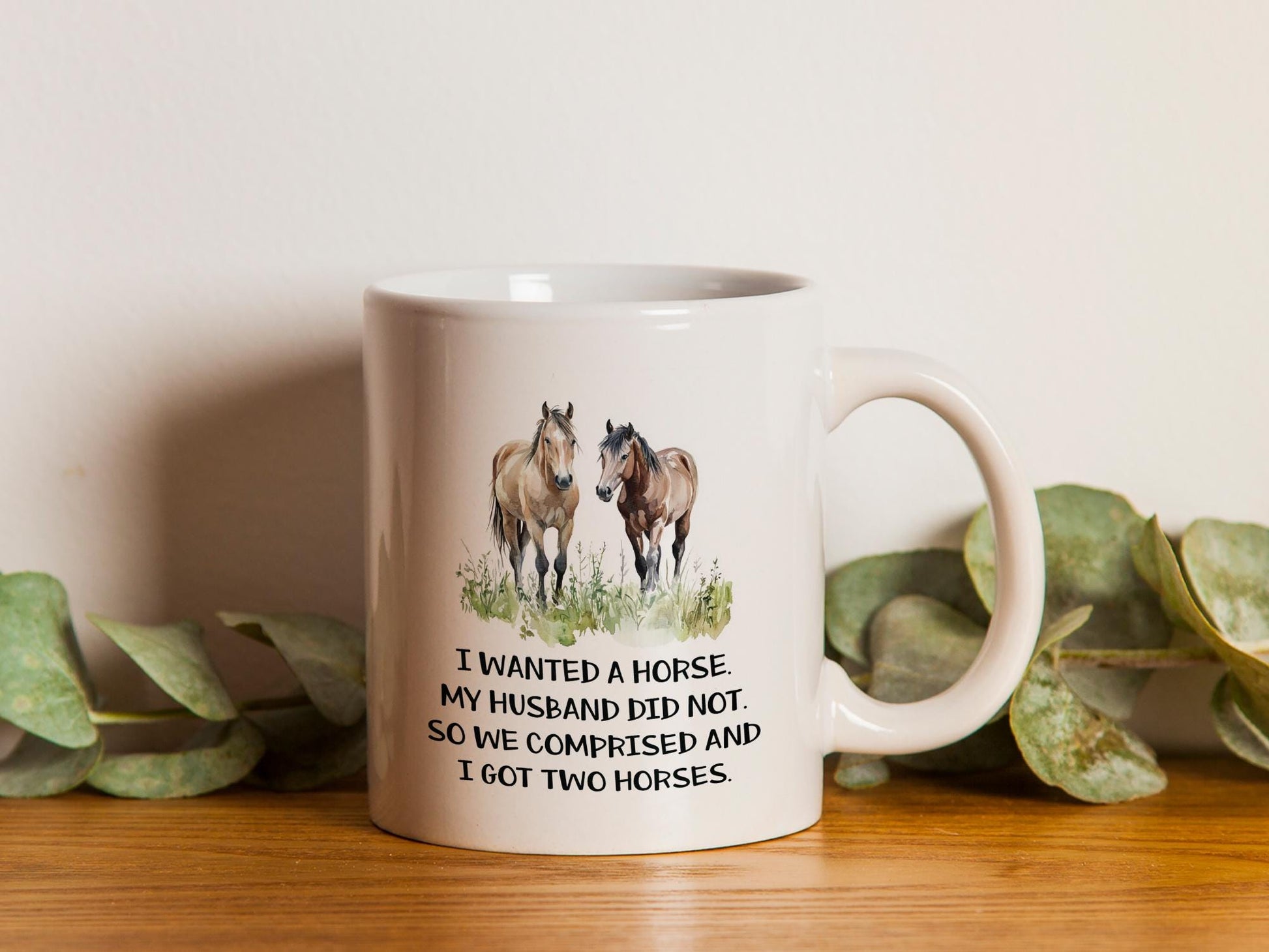 a white coffee mug with two horses on it